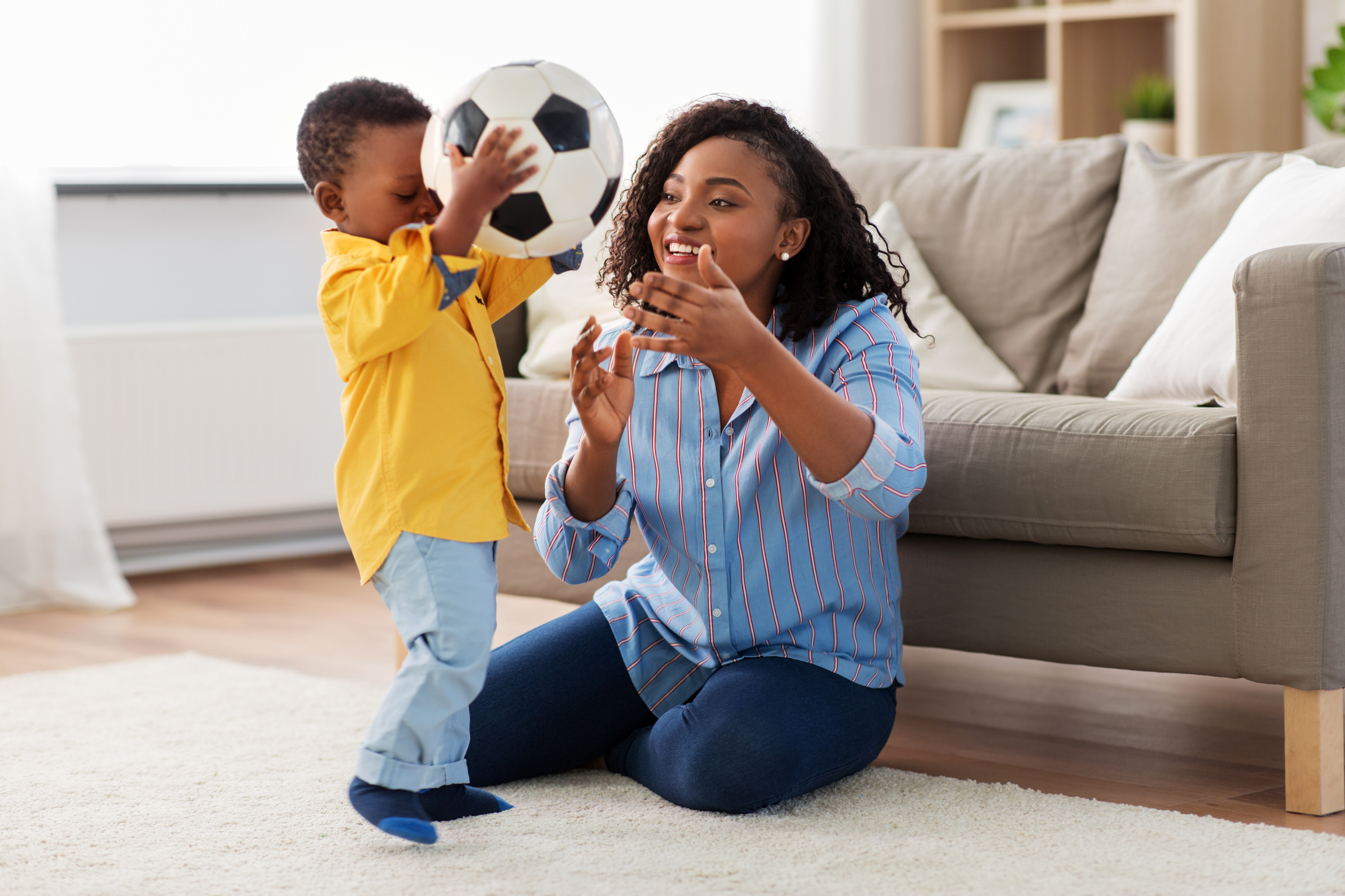 Mother and Baby Playing with Soccer Ball at Home